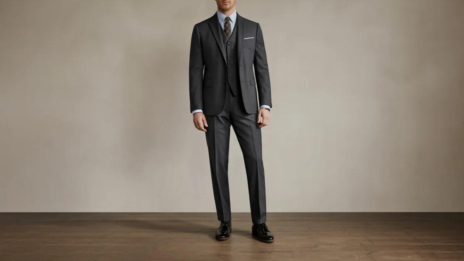 A man in a suit stands confidently in a well-lit room, exuding professionalism and poise