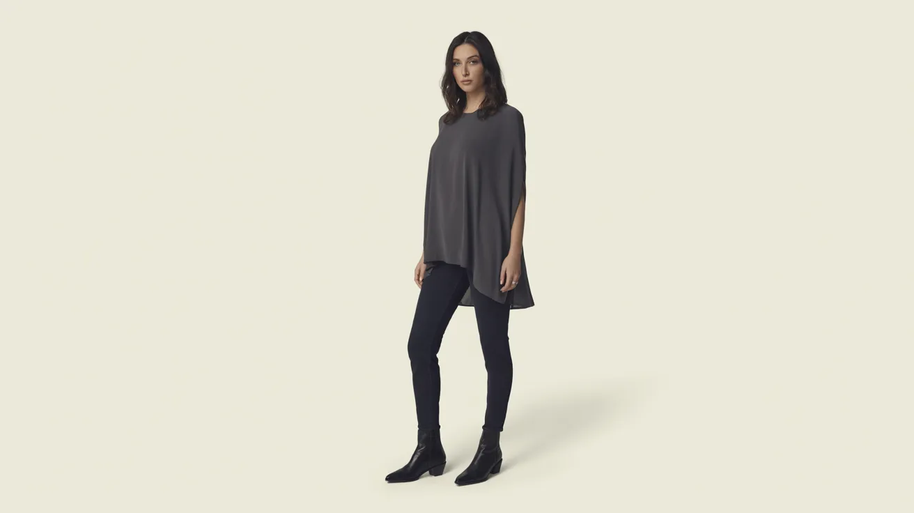 A model poses in a grey top paired with black jeans, showcasing a casual yet stylish outfit.