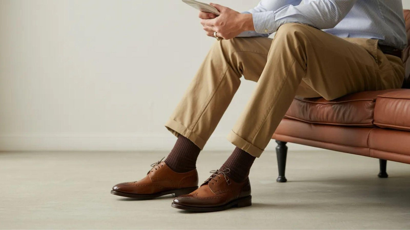 A man relaxes on a couch with his feet propped up, enjoying a moment of leisure in a cozy living room setting.