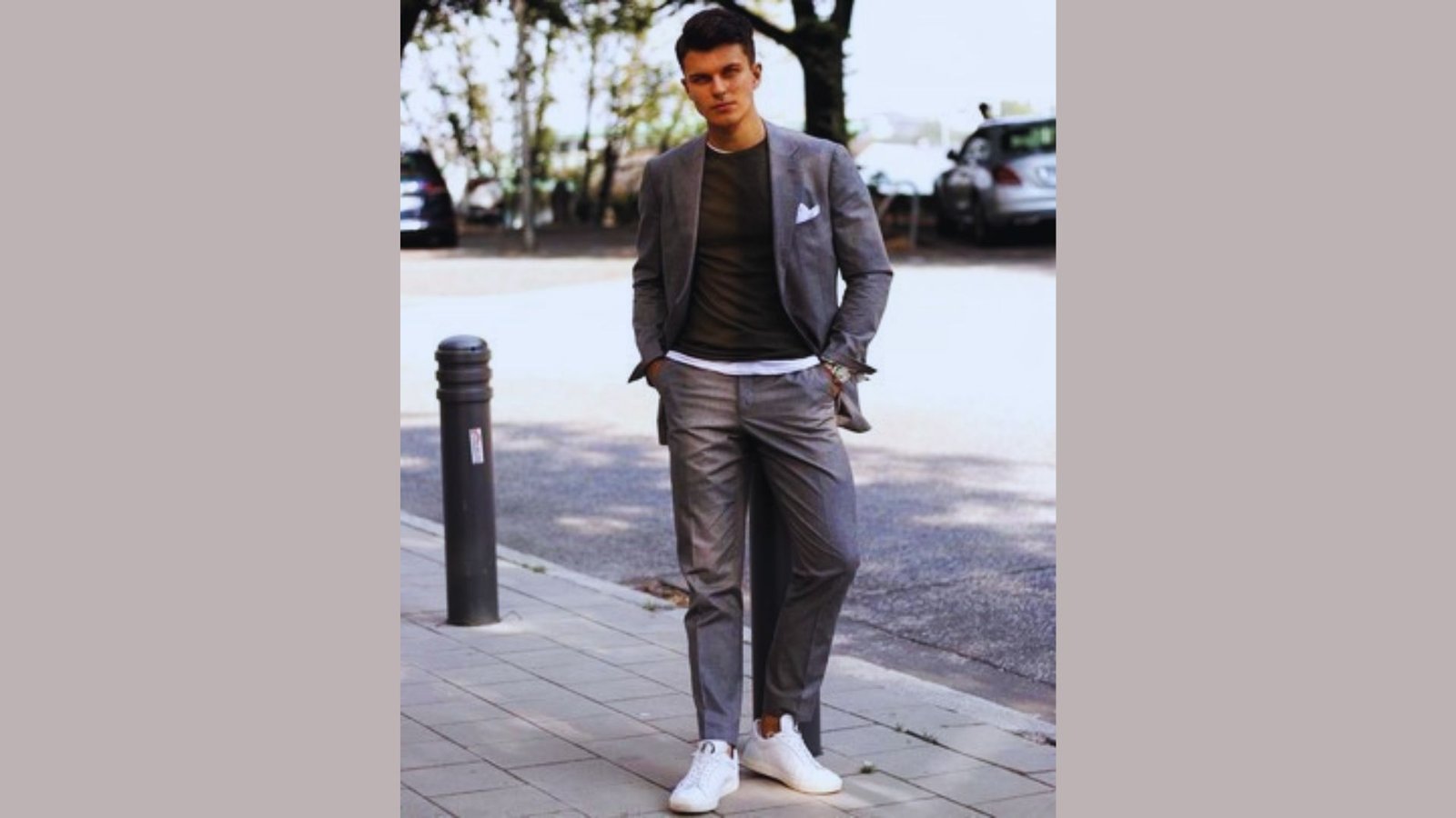 A man dressed in a formal suit and white sneakers, illustrating the trend of combining elegance with casual footwear.
