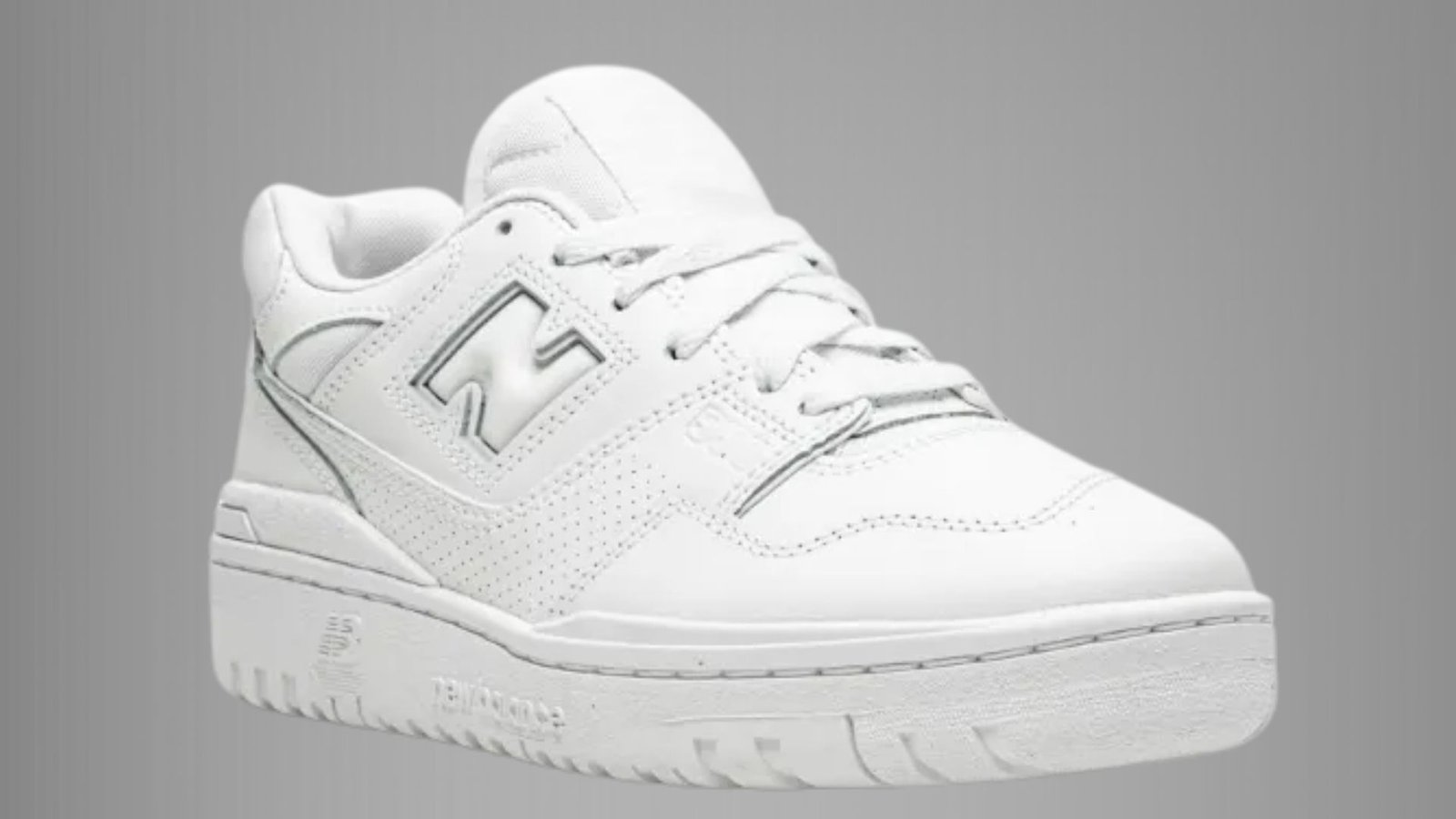 New Balance 574 sneakers in white, featuring a classic design with a cushioned sole and signature logo on the side.