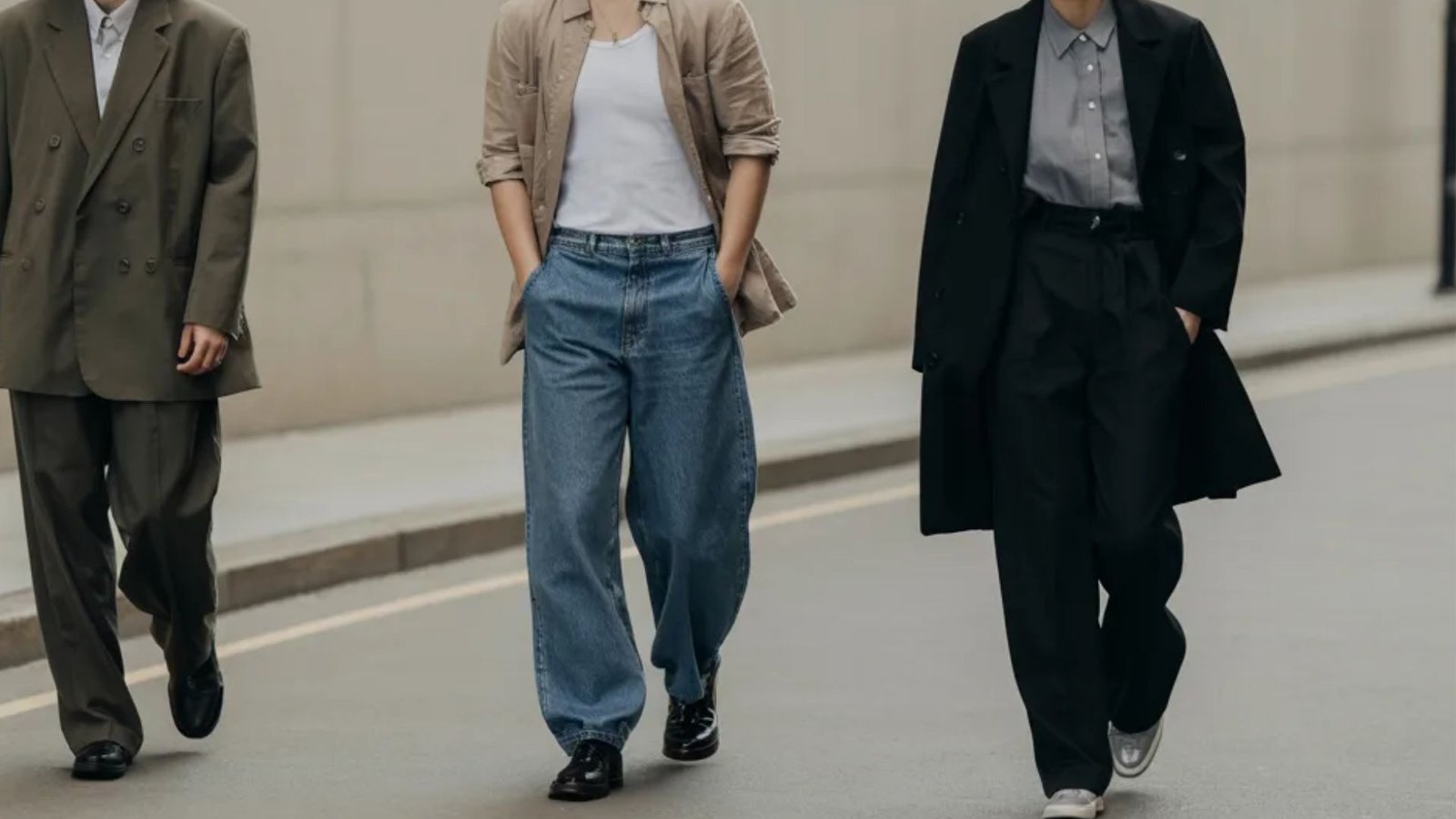 A trio of individuals in business suits walking side by side on a bustling street.