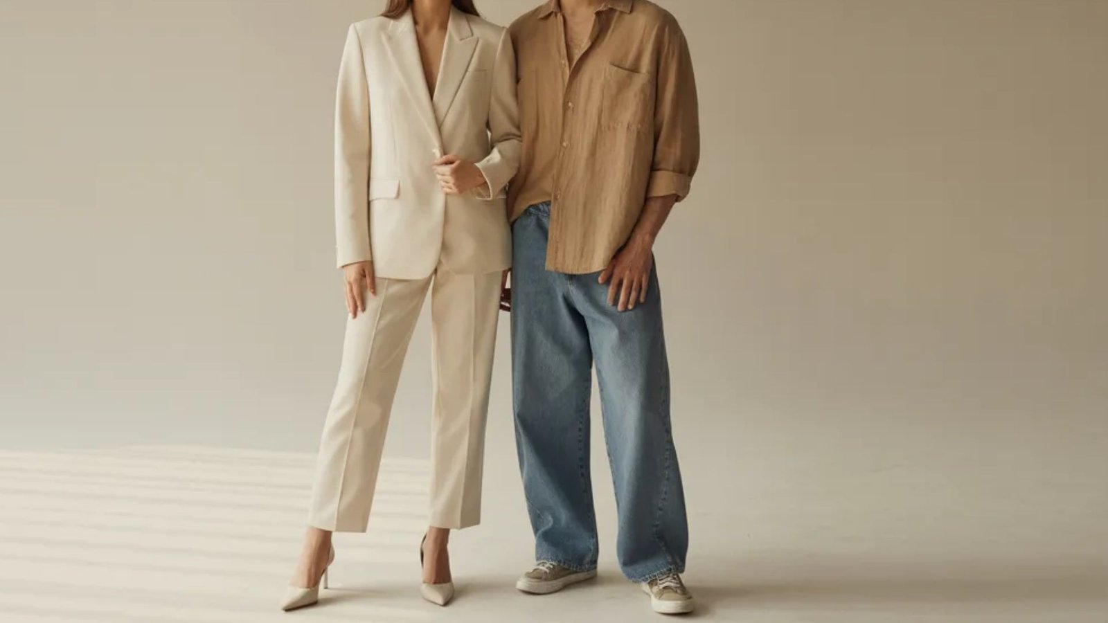 A man and woman wearing a beige suit and white shirt, standing together in a professional setting.