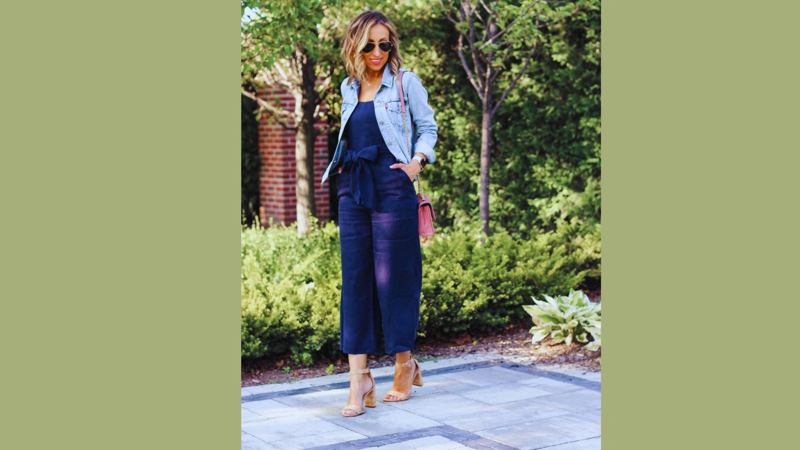  A woman dressed in a blue jumpsuit and denim jacket, showcasing a stylish and casual outfit.
