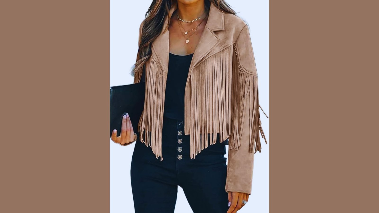  A woman in a tan suede jacket and black pants stands confidently, showcasing a stylish boho-inspired outfit.
