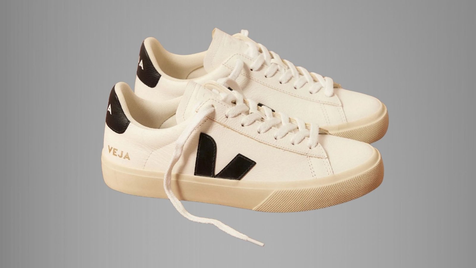A pair of white sneakers featuring black and white logos on the sides.