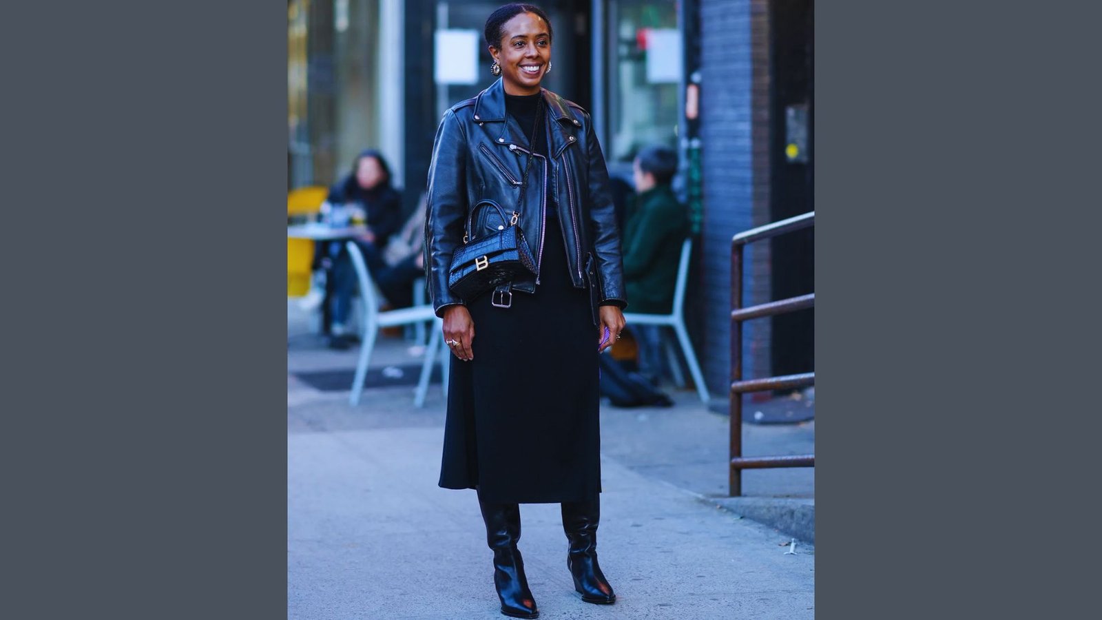 A woman wearing a black leather moto jacket and skirt, styled for a date night or dinner outing.
