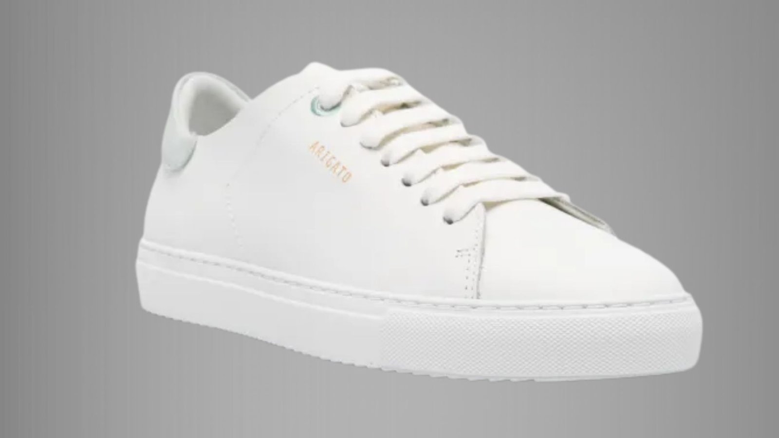 A white leather sneaker featuring a sleek design and a matching white sole.