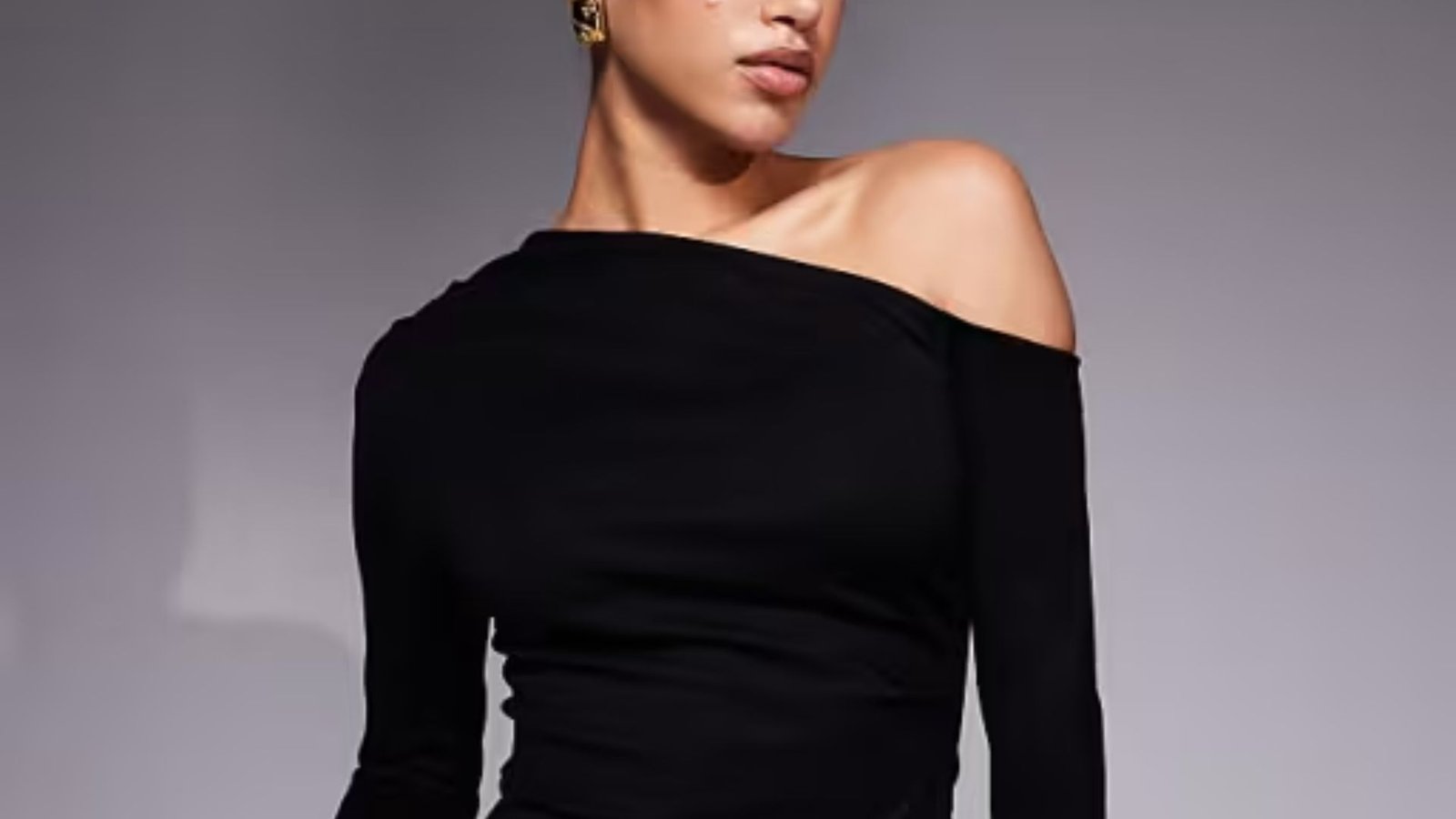 A woman wearing a stylish black one-shoulder top, showcasing a modern and elegant fashion choice.