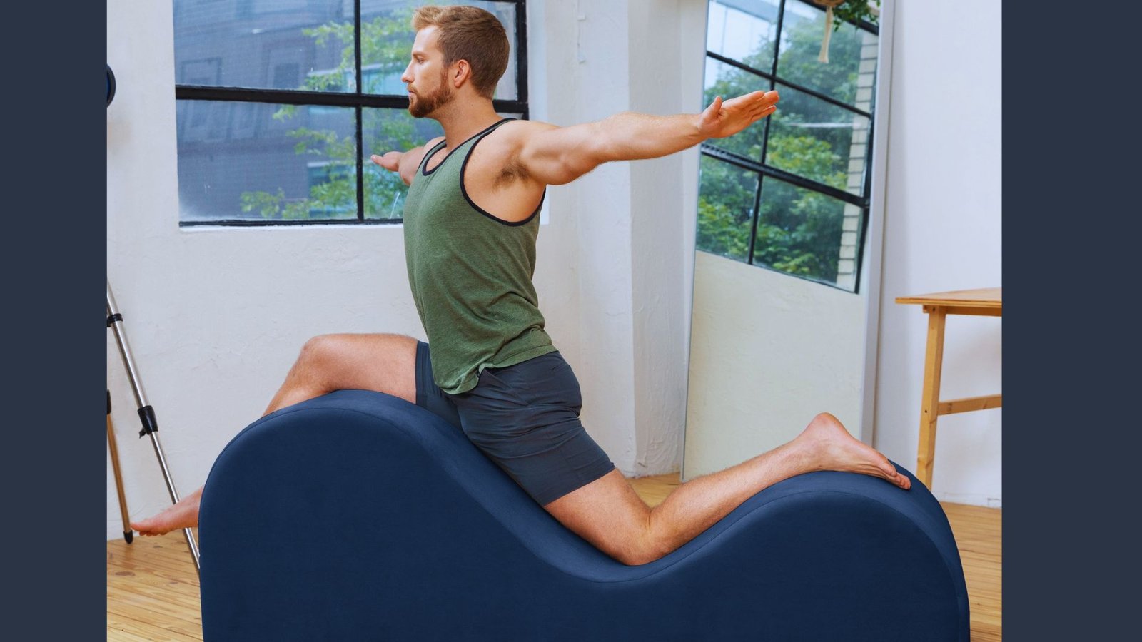 A man performs a yoga pose on a foam exercise ball, showcasing balance and flexibility in a lounge-ready setting.
