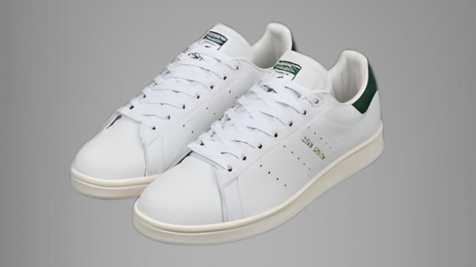 White adidas Stan Smith sneakers with green accents on the heel and tongue, showcasing a classic and sporty design.