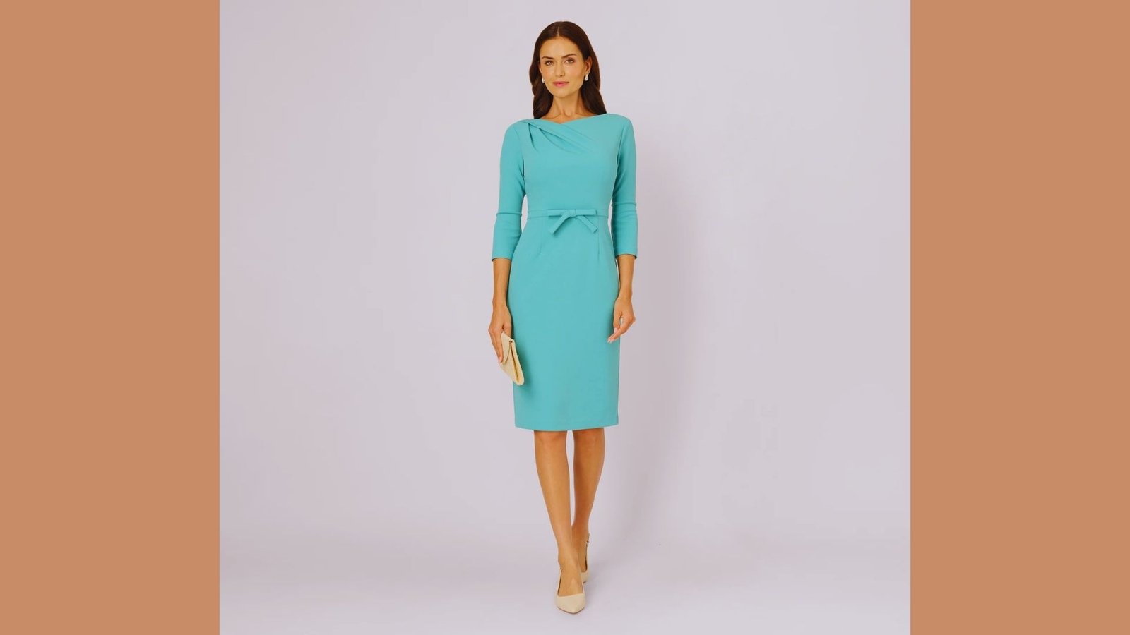 A woman poses confidently in a fitted turquoise sheath dress, showcasing her style and elegance.