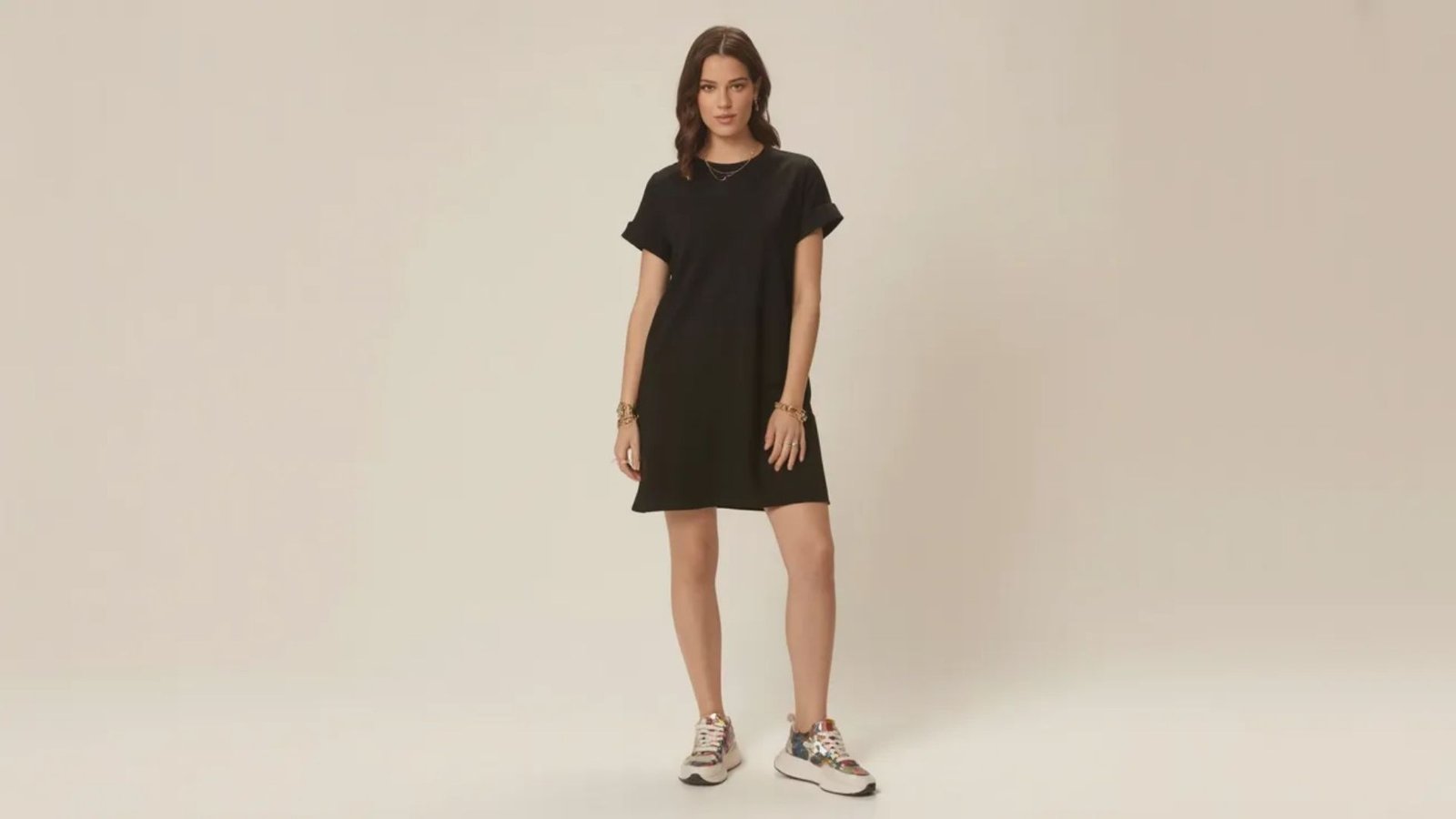 model showcases a black dress paired with stylish sneakers, blending elegance with casual comfort.