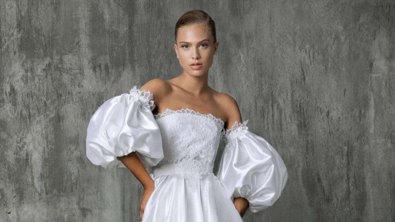 A woman wearing a white wedding dress stands gracefully, embodying elegance and joy on her special day.