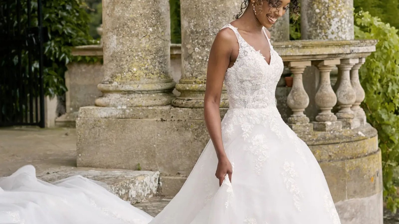 A beautiful bride in an elegant wedding dress stands gracefully on the steps, radiating joy and anticipation.