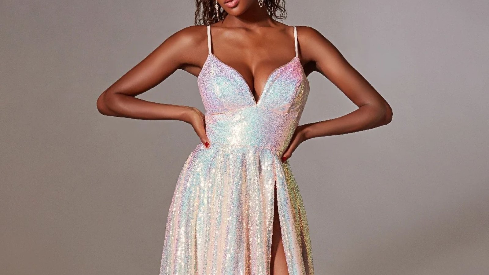 A model showcases a vibrant pink and blue sequin dress, reflecting light with its shimmering surface.