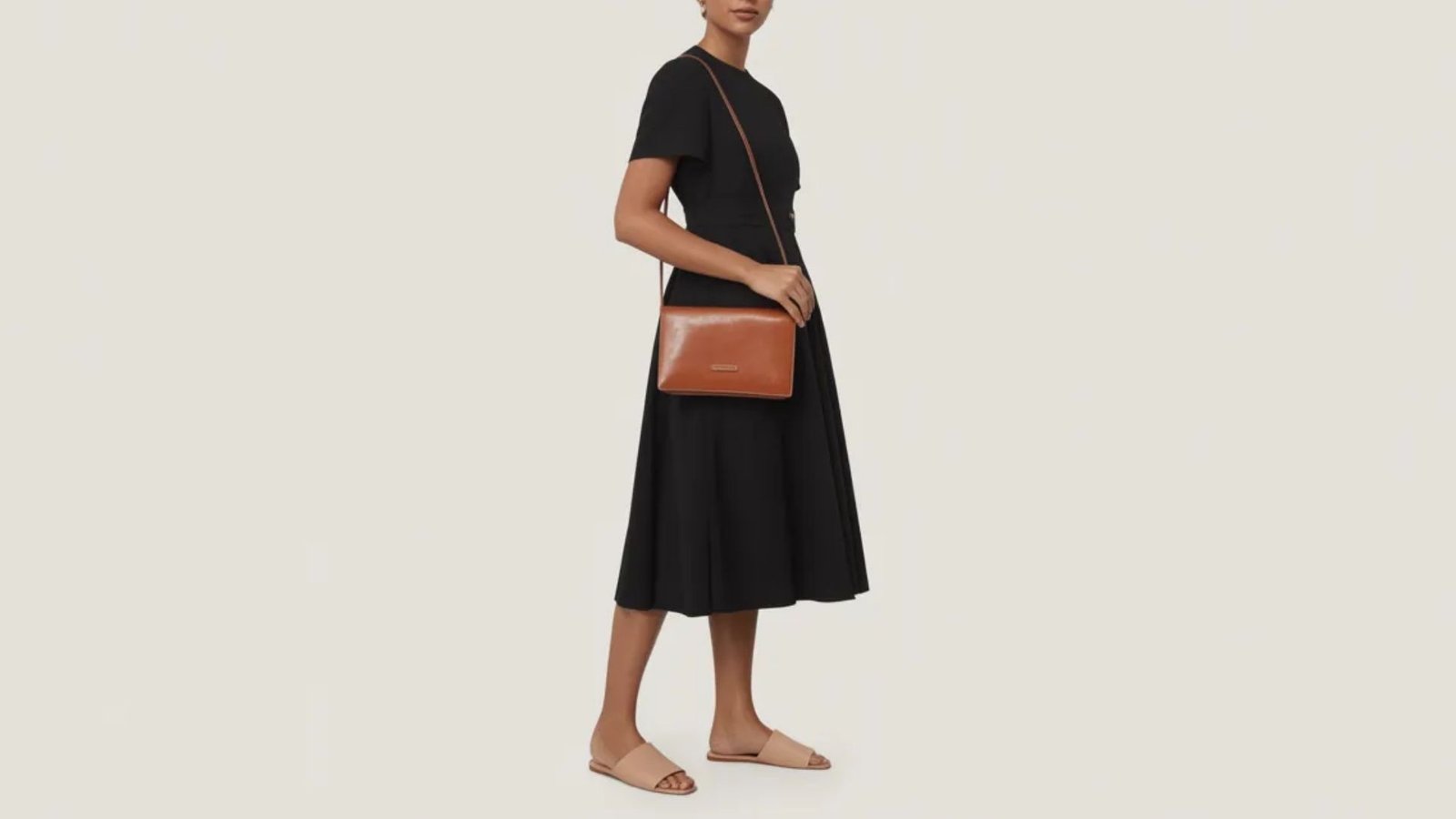 A stylish row leather crossbody bag in a rich brown color, featuring a sleek design and adjustable strap.