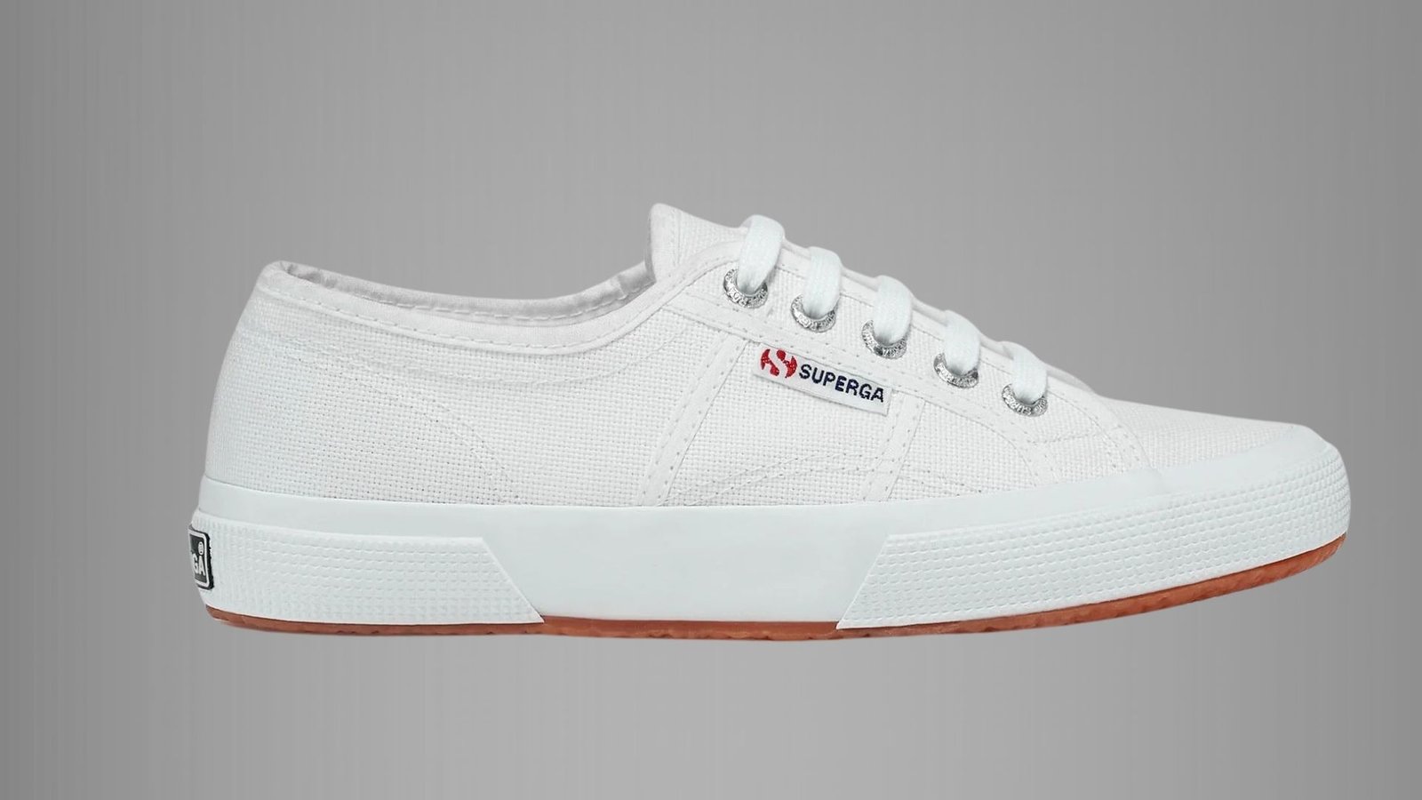 White Superga 2750 Cotu sneakers displayed on a neutral background, showcasing their classic canvas design and rubber sole.