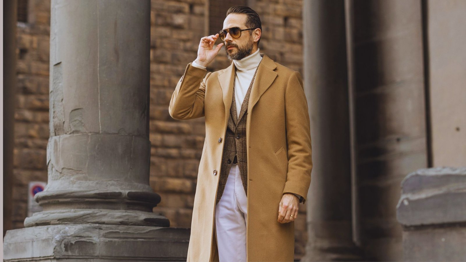 A man wearing a camel coat and white pants, embodying a neutral color palette and quiet luxury aesthetic.
