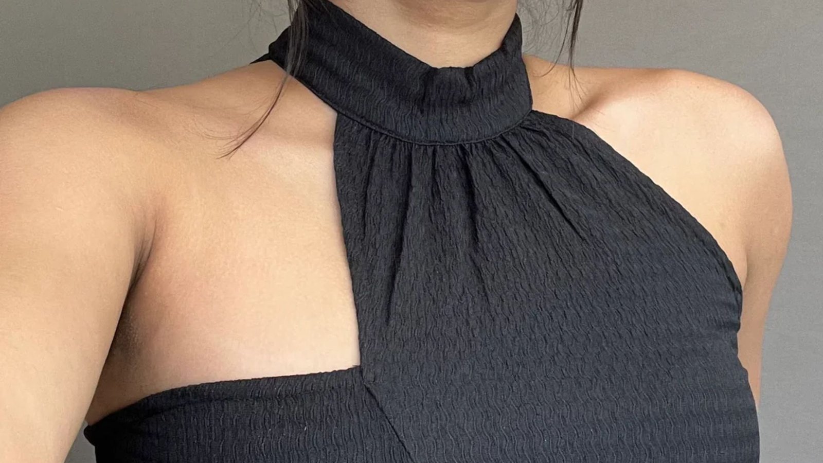 A woman in a black top and necktie, exuding a professional and stylish appearance.