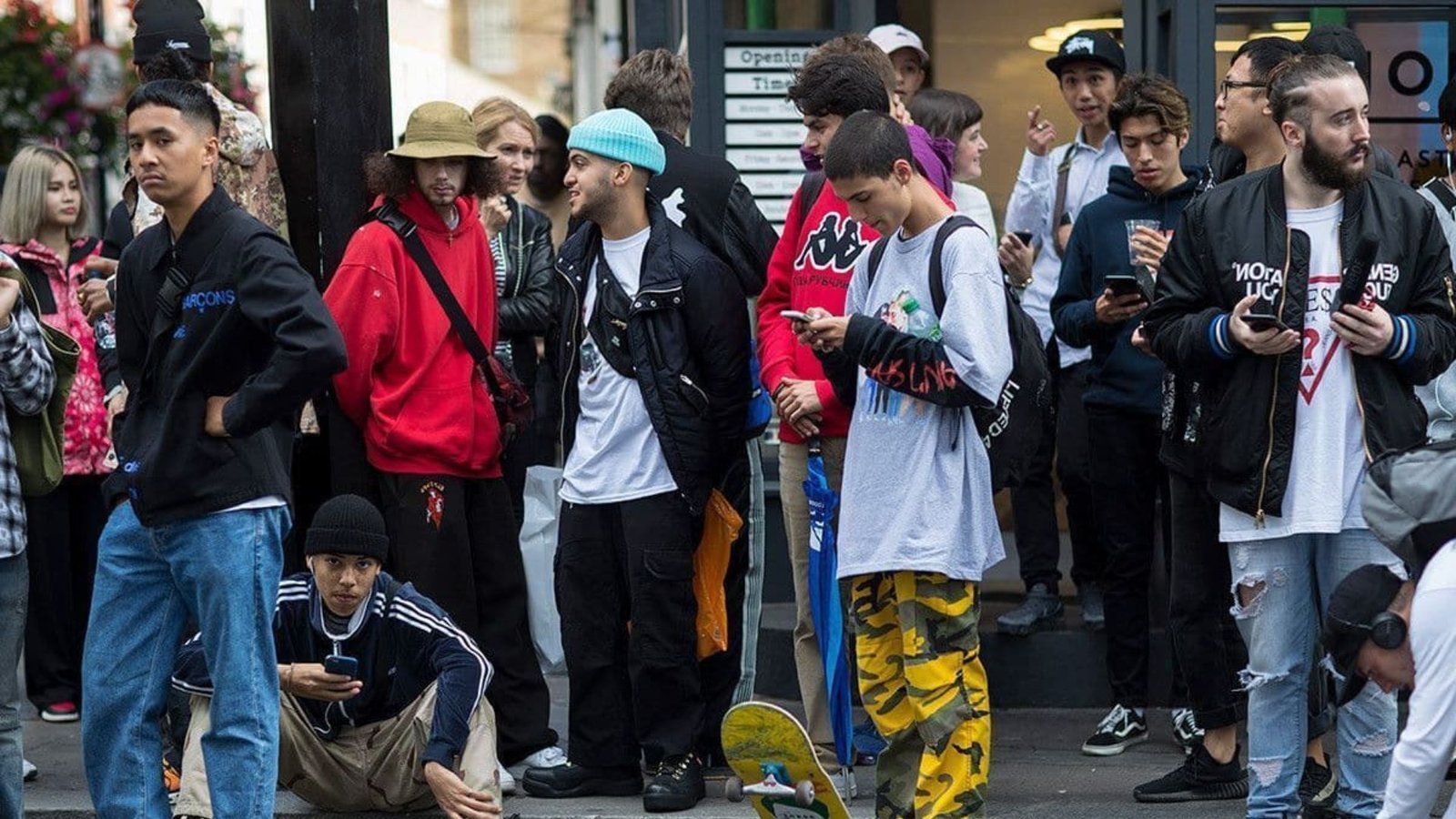 A group of people watches and cheers as a skateboarder performs tricks at a skate park.
