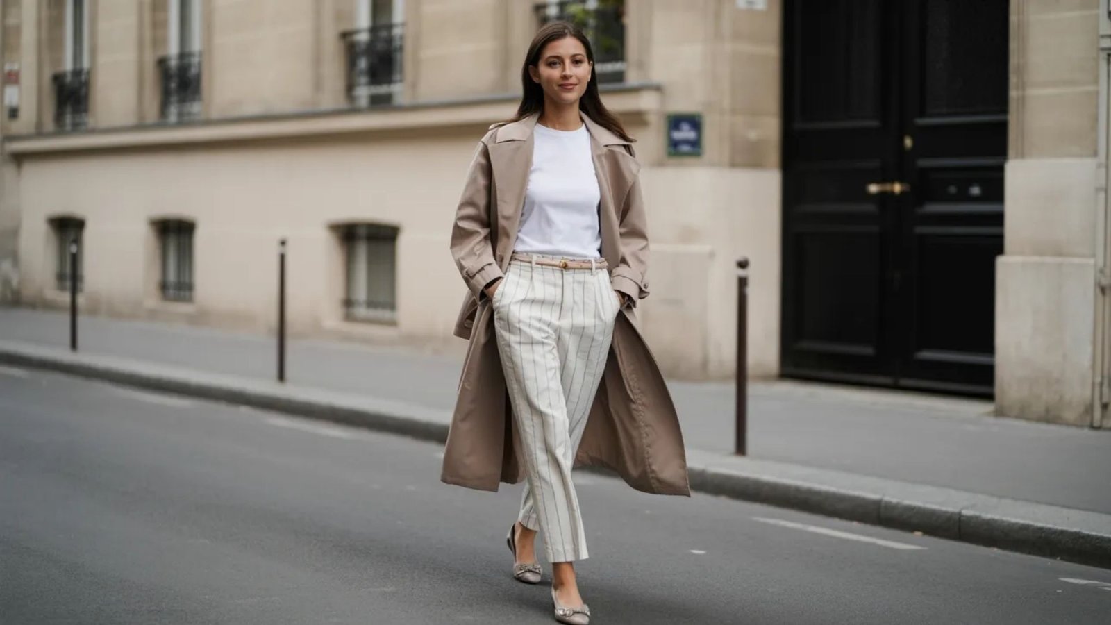 A woman dressed in white walking along a street, surrounded by urban scenery.