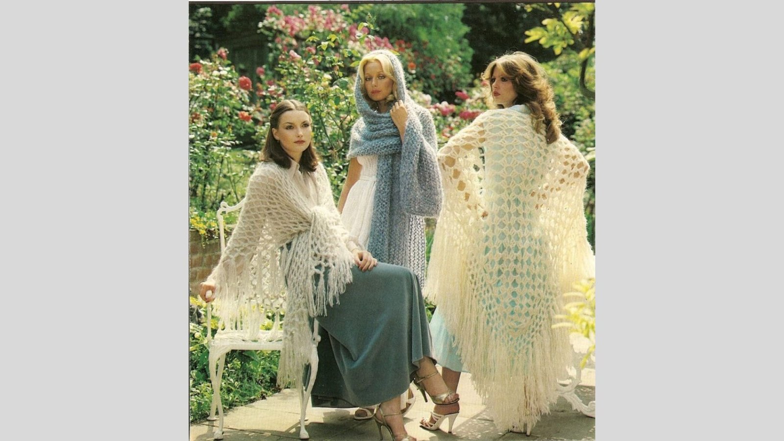 Three women in colorful shawls and dresses sit together on a bench, enjoying a moment of conversation and companionship.