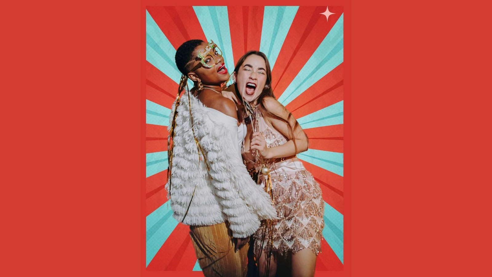 Two women in stylish outfits pose joyfully against a vibrant red and blue starburst background. One wears a furry jacket and mask; the other a sparkly dress.