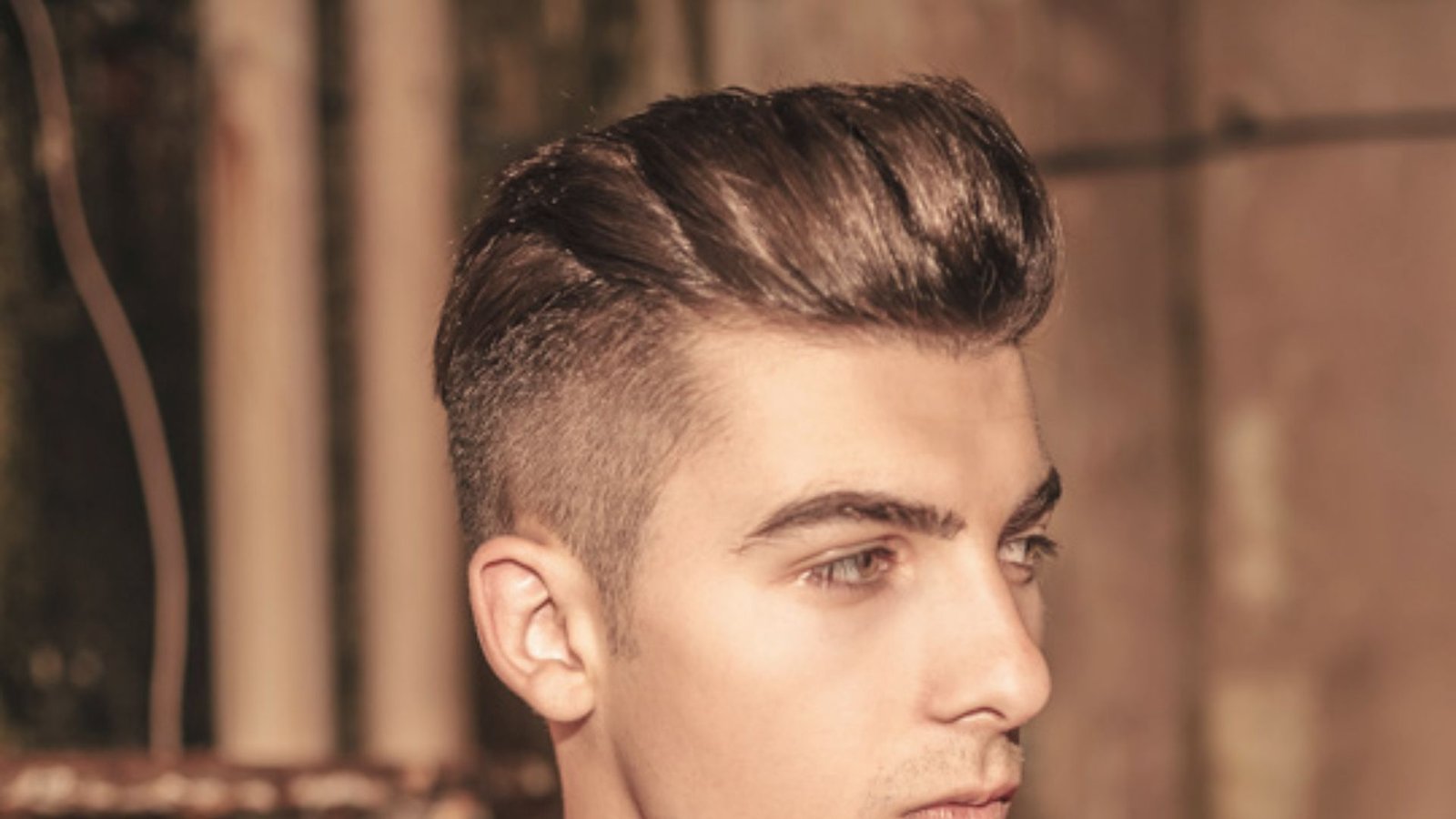 A man with a high volume disconnected undercut fade hairstyle and short hair.