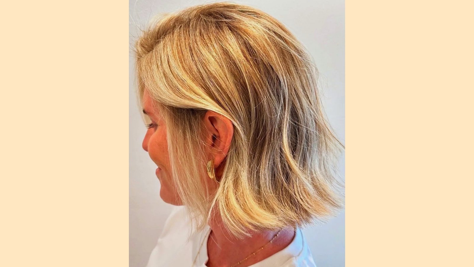 Side profile of a textured blonde French bob without bangs, shoulder-skimming length with piecey layered ends