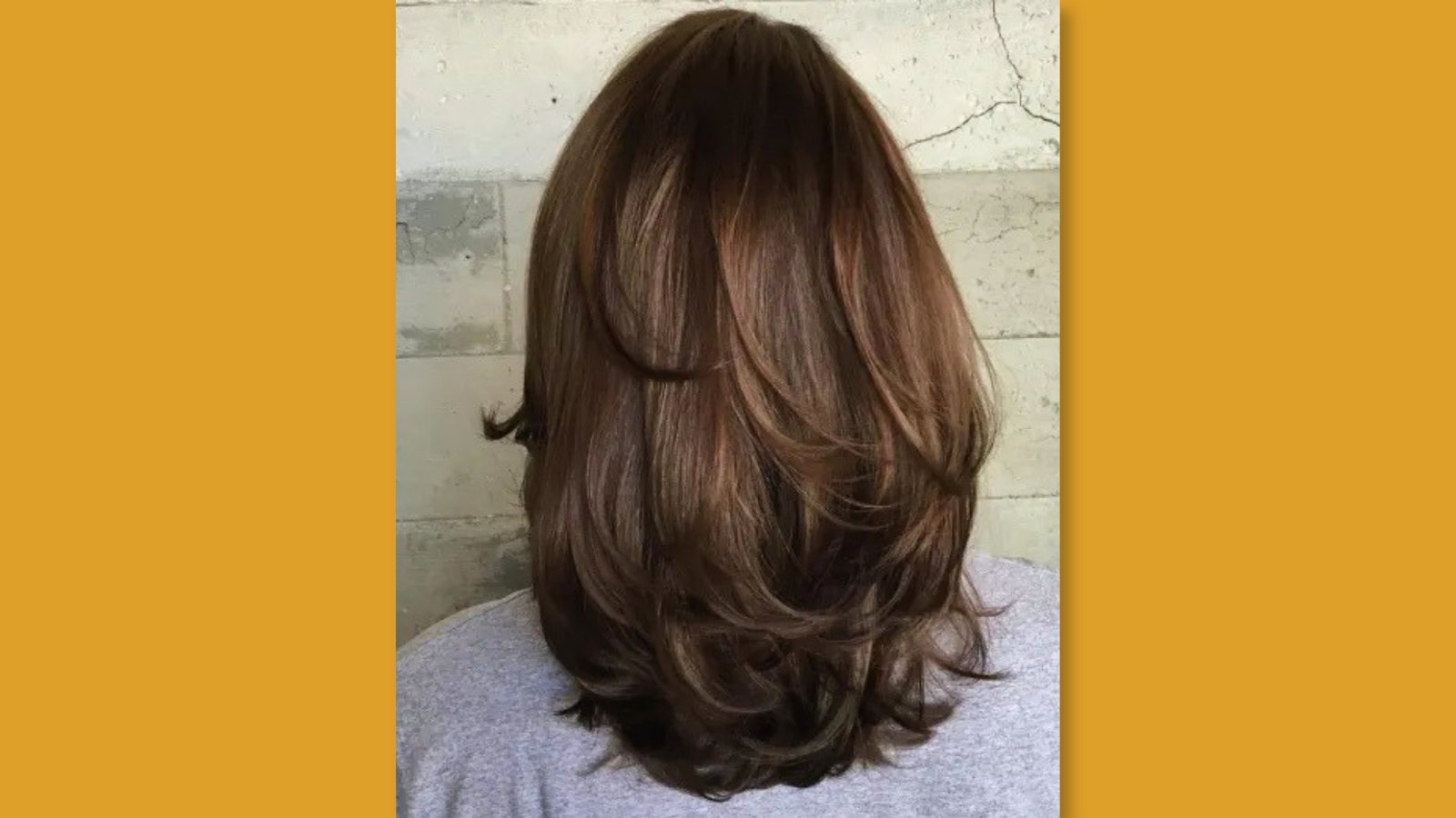 Back view of low maintenance layered medium length haircut with bouncy flipped layers and movement on brown hair for round face 
