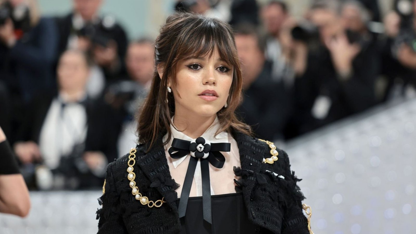 Woman at a formal event with hair in a half-up style and wispy bangs.
The piecey, eyebrow-skimming fringe has longer sides that curve into face-framing layers.