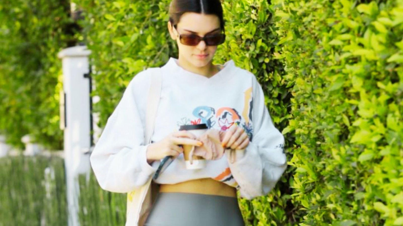 A woman dressed in leggings and an oversized t-shirt sits on a bench, representing a relaxed and practical outfit choice.