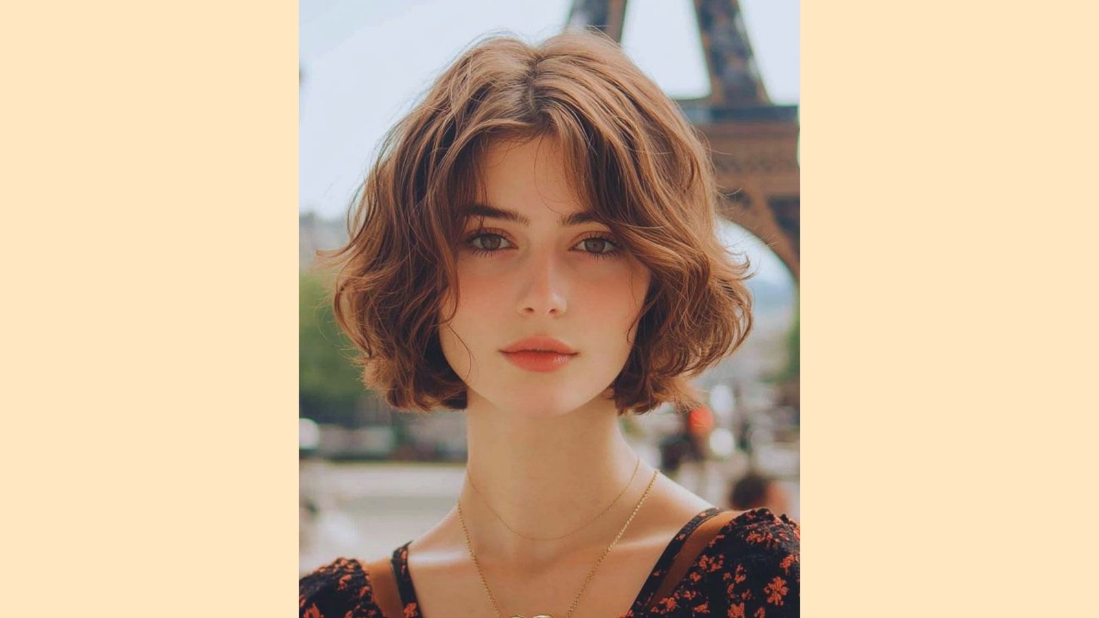 Wavy auburn French bob with curtain bangs and center-parted soft layers, Eiffel Tower in background