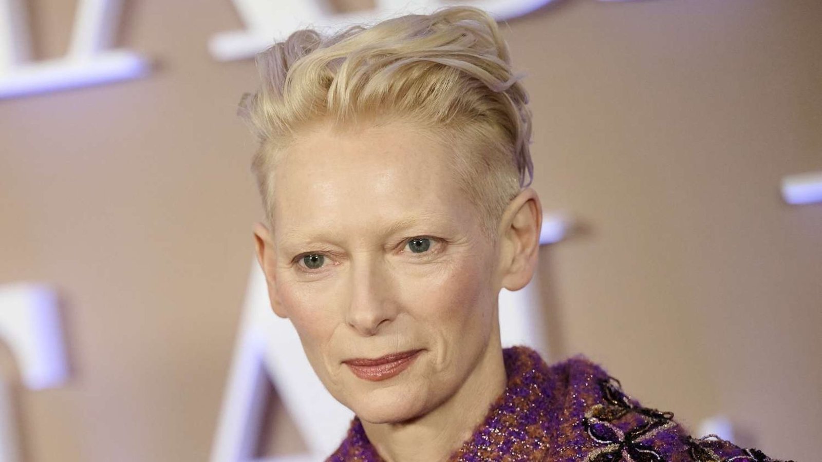 Person with short platinum blonde hair styled in a swept-up quiff and faded undercut. Shaved sides blend into the longer textured top for a bold, androgynous red-carpet style.