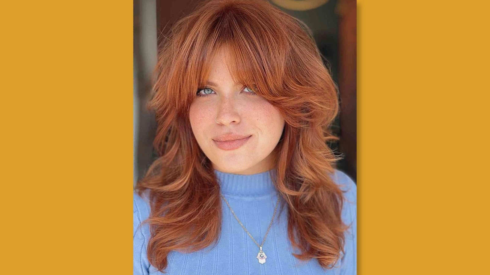 Low maintenance layered medium length shag haircut with wispy curtain bangs and choppy texture on copper red hair for round face 
