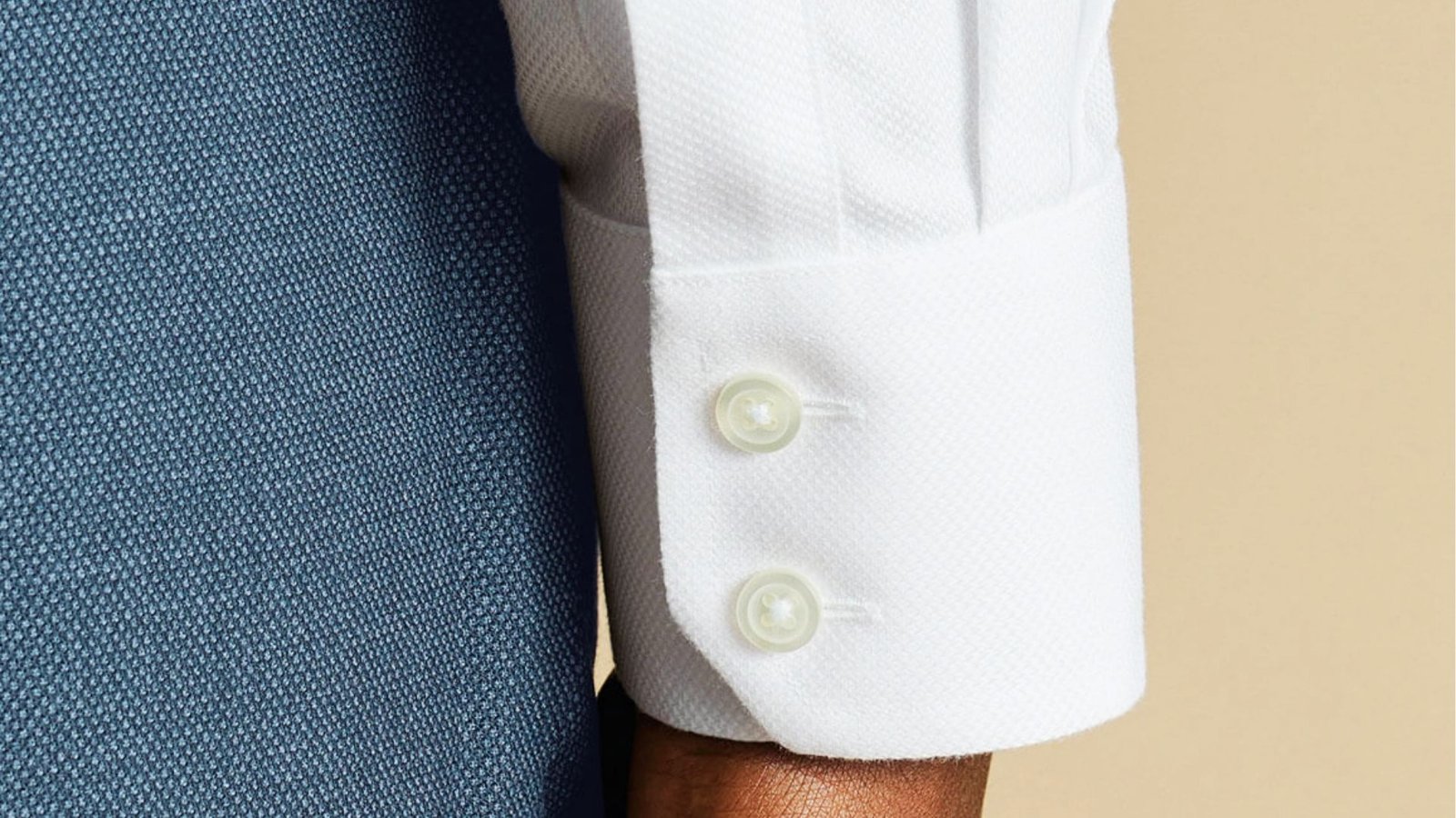  A close-up of a man's hand wearing a white barrel cuff shirt
