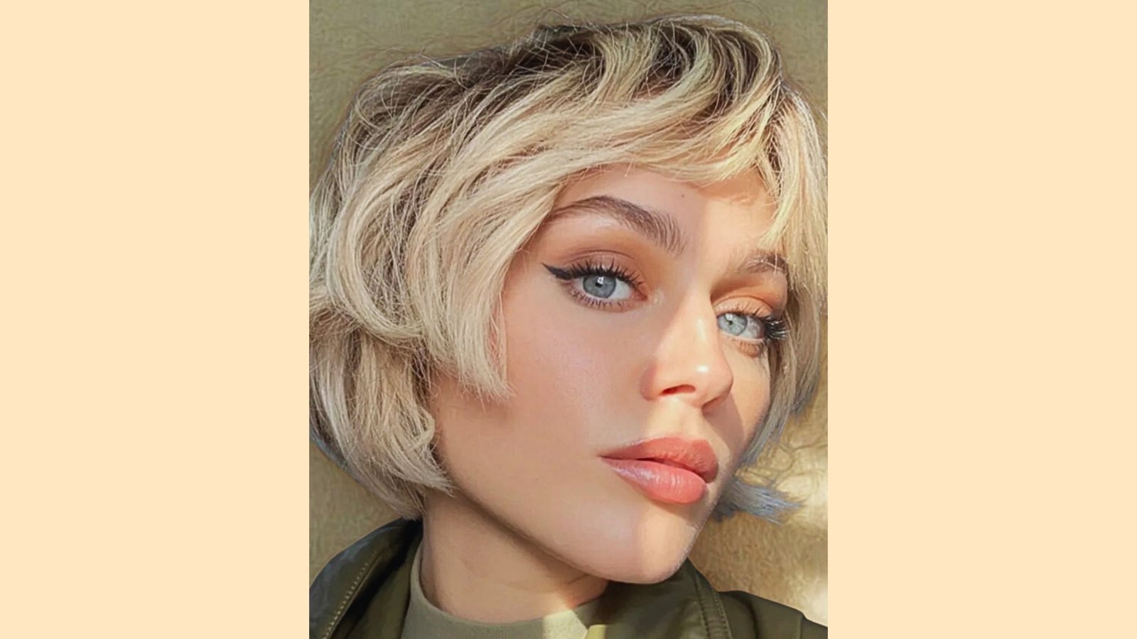 Tousled platinum blonde French bob with piecey face-framing bangs and choppy wavy texture