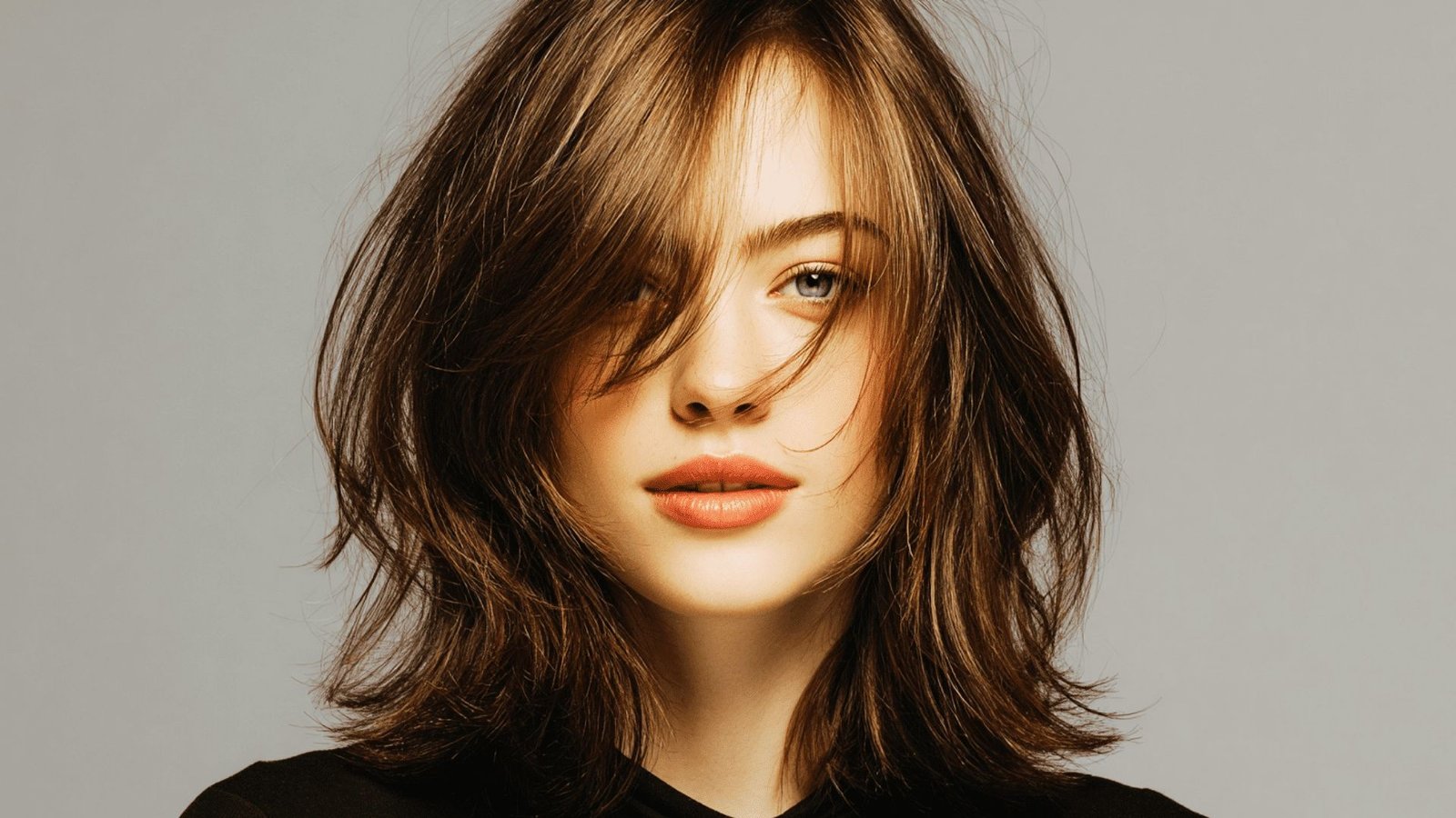 A Woman with Face-Framing Layers with Long Curtain Bangs
