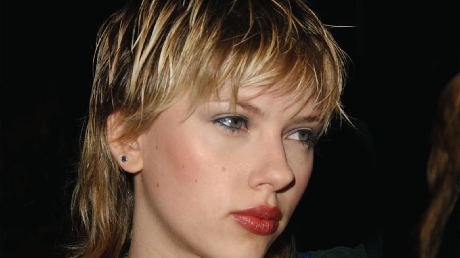 Side view showcasing a Y2K spiky mullet hairstyle with short, straight hair.