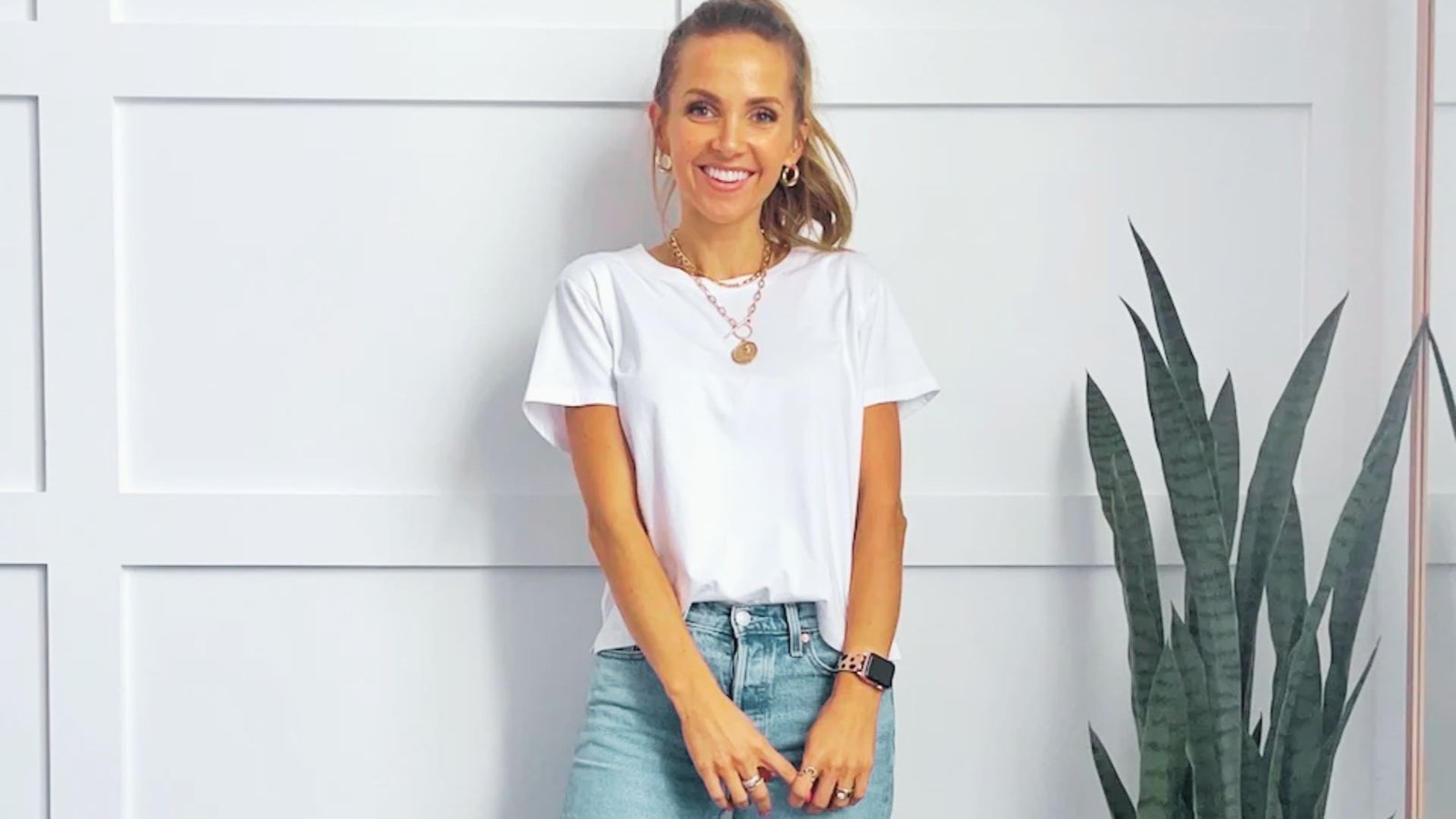 A woman wearing a white t-shirt and jeans, embodying a classic, casual mom style suitable for everyday activities.
