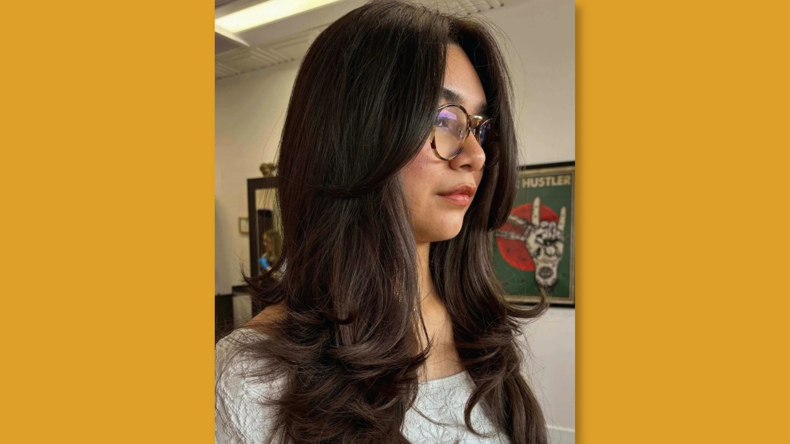 Medium length layered haircut with soft face-framing layers and curtain bangs on glossy dark brunette hair for round face
