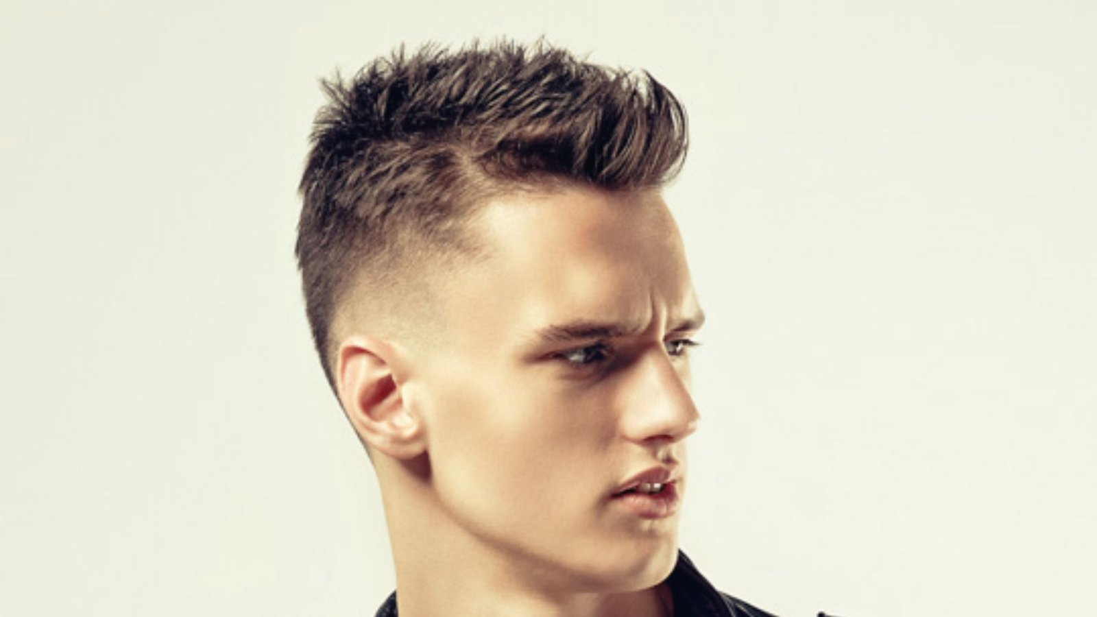 A young man with a short Angular Fringe Disconnected Undercut Fade hairstyle.