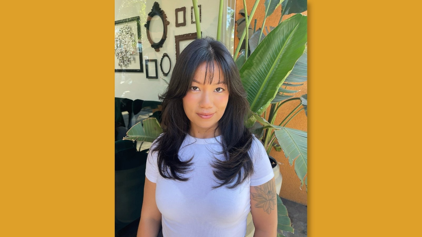 Low maintenance layered medium length haircut with wispy bangs and bouncy face-framing layers on dark brown hair for round face 
