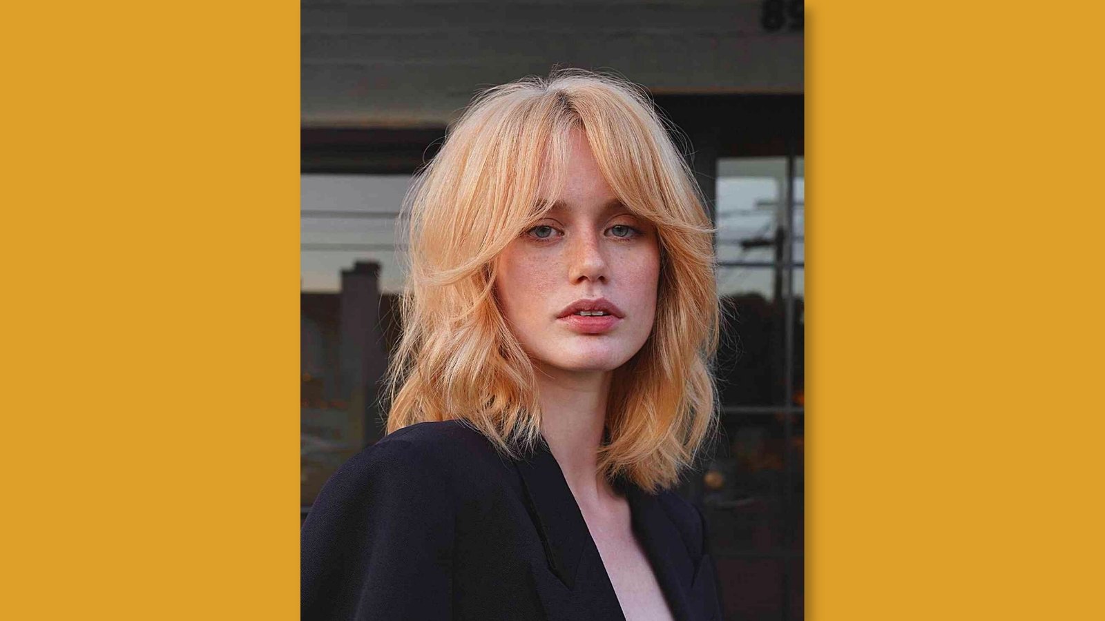  Low maintenance layered medium length shag with wispy curtain bangs and tousled texture on strawberry blonde hair for round face 
