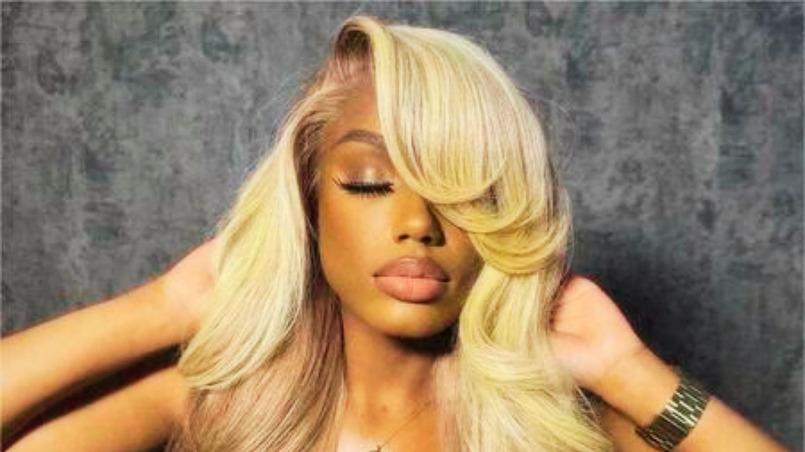 A woman with long hair featuring abundant volume and long swoopy bangs, representing a stylish hair trend.

