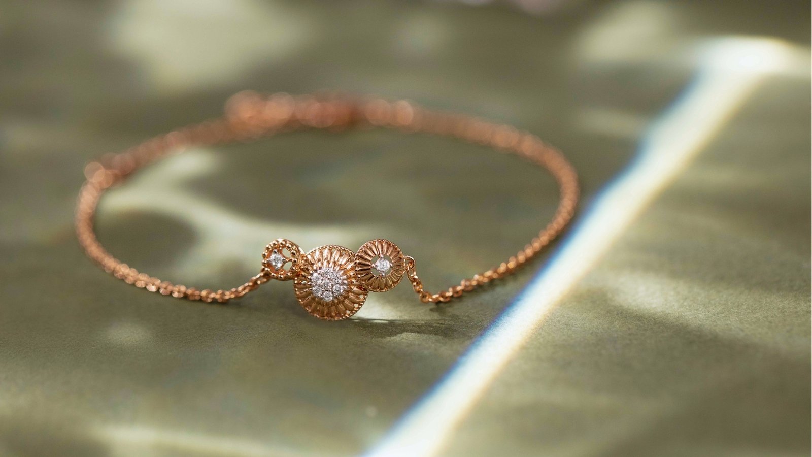 Elegant rose gold bracelet with two flower-shaped designs adorned with diamonds, placed on a softly lit surface, conveying sophistication and luxury.