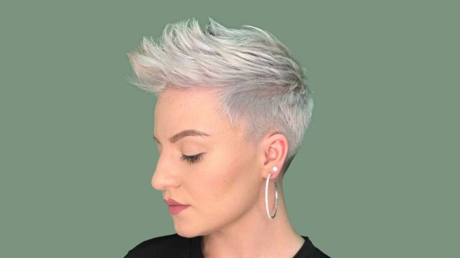 Woman in profile with a silver-white spiky pixie undercut and fade.