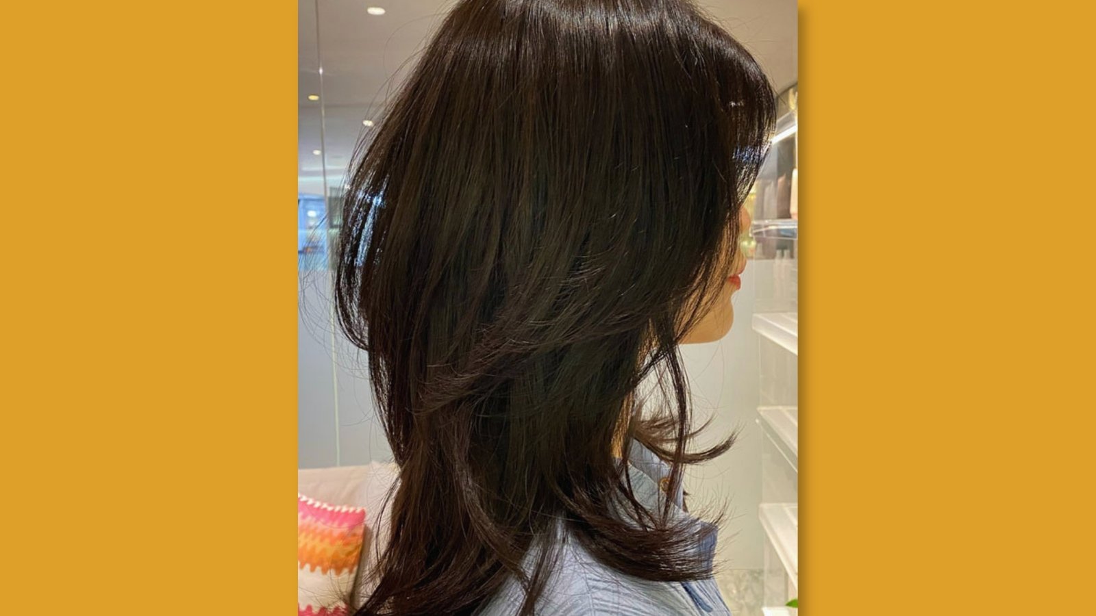 Side view of low maintenance long layered haircut with soft curtain bangs and voluminous layers on dark brown hair for round face 
