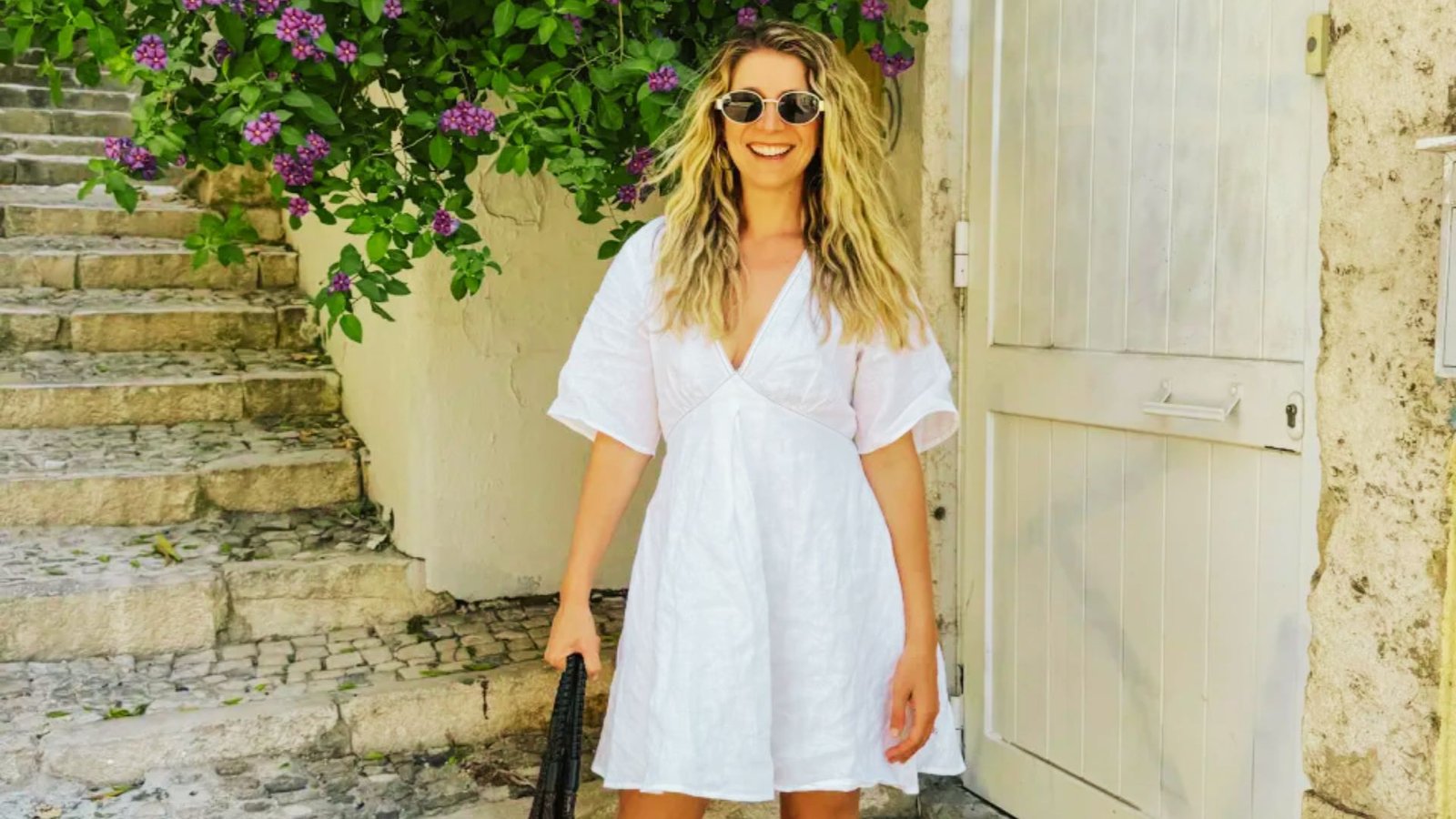 A woman in a white dress and sunglasses, embodying effortless style and modern mom fashion for busy lifestyles.
